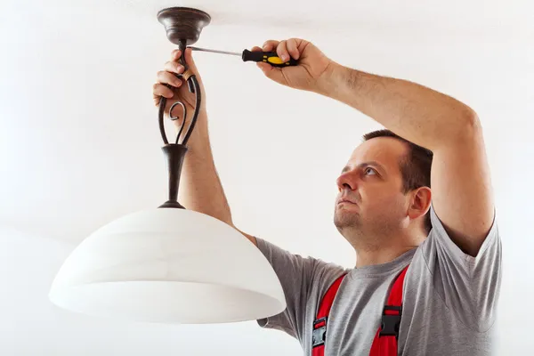 Electricista montaje lámpara de techo —  Fotos de Stock