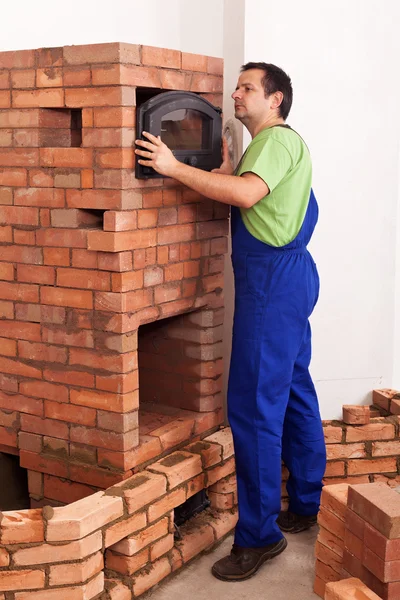 Trabalhador construindo um aquecedor de alvenaria — Fotografia de Stock