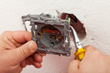 Elektrikçi elektrik duvar fikstür için telleri bağlarken