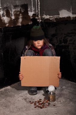 Poor beggar child on the street with blank sign clipart