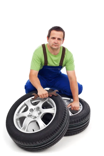 Mecânico de carro com pneus novos — Fotografia de Stock