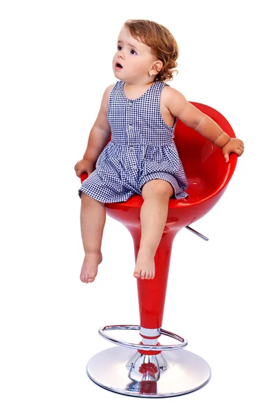 Kis tipegő lány piros bárszék — Stock Fotó