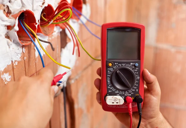 Manos electricistas con multímetro y cables — Foto de Stock