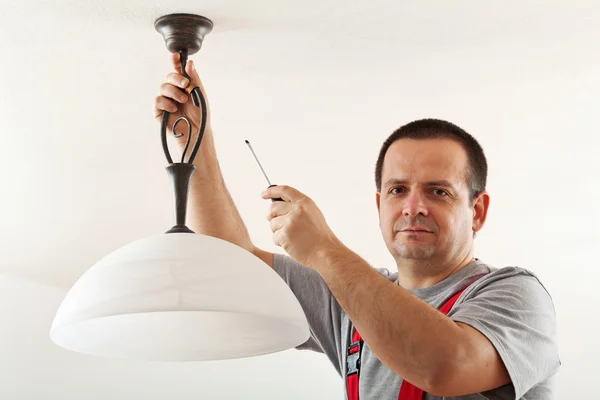 Electrician mounting ceiling lamp — Stock Photo, Image