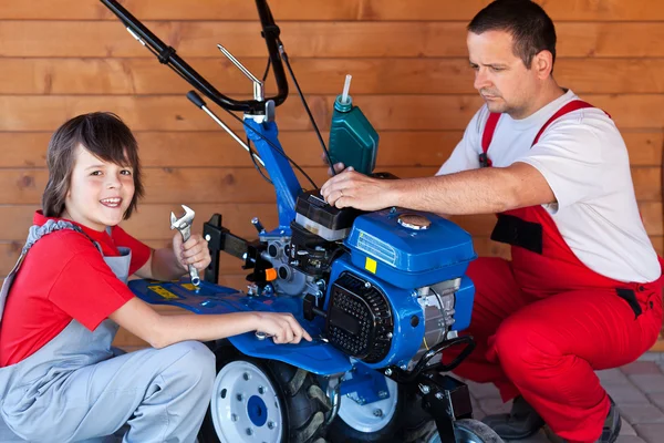 Uomo e ragazzo che preparano una macchina coltivatrice per il lavoro — Foto Stock