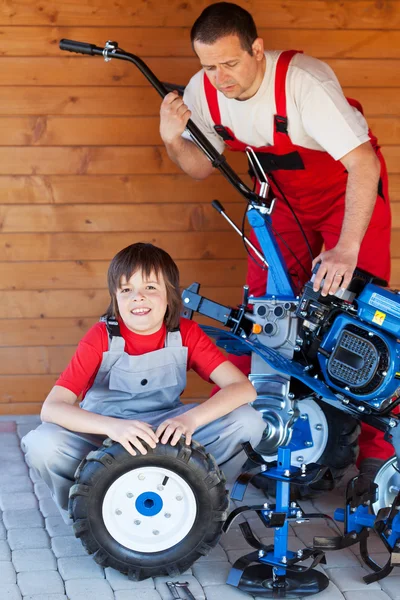 Άνθρωπος και αγόρι συντήρηση μια μηχανή καλλιεργητή — Φωτογραφία Αρχείου