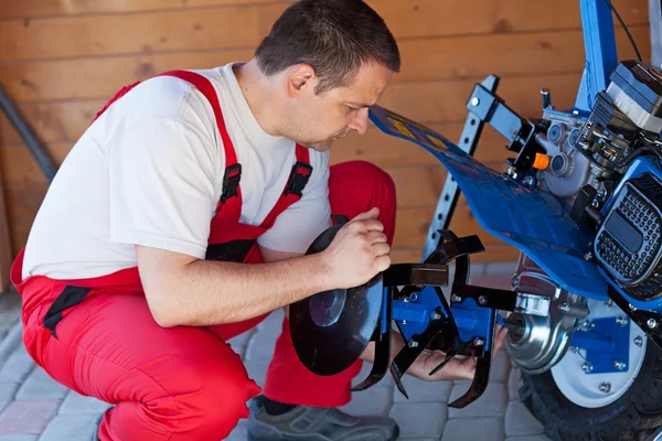 Arbeiter montiert Ackerbauzubehör auf einer Grubber-Maschine — Stockfoto