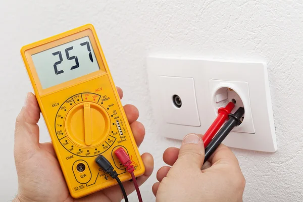 Electrician hands with multimeter — Stock Photo, Image