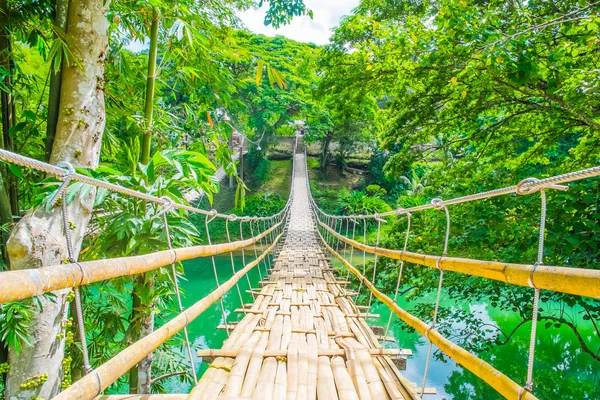 Ponte de suspensão pedonal de bambu sobre o rio — Fotografia de Stock
