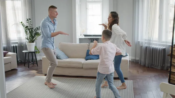 En ung familie i leiligheten. Pappa, mamma og lille sønn danser.. – stockfoto