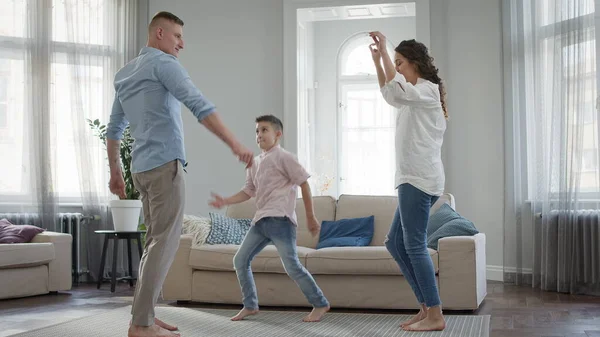En ung familie i leiligheten. Pappa, mamma og lille sønn danser.. – stockfoto