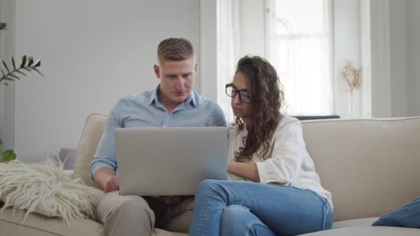 Unge par på sofistikeret ser på noget i bærbar computer. – Stock-video