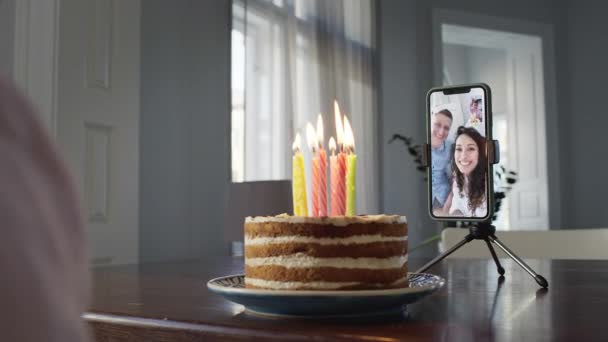 Chlapec sedící před dortem u stolu. Telefon na stole. — Stock video