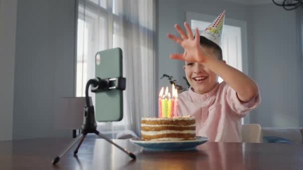 케이크 앞에 앉아 있는 소년. — 비디오