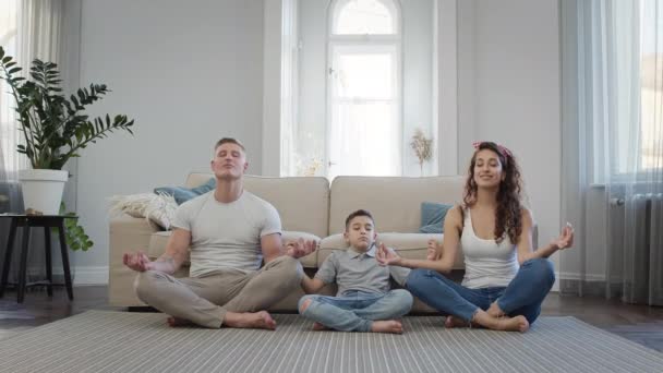 Familia joven en el apartamento en el piso Meditando. — Vídeo de stock