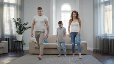 Baba, anne ve oğul evde egzersiz yapıyor. Genç Aile.