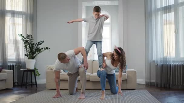 Pappa, mamma och son tränar i lägenheten. Mamma och pappa satte ett knä på golvet. — Stockvideo