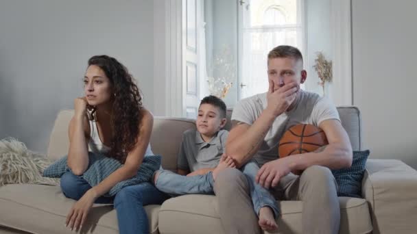 部屋のソファの上の若い家族。彼らはスポーツゲームのためのテレビと応援. — ストック動画