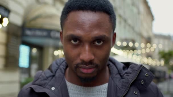 Um negro sério na rua. Ele levanta a cabeça baixa. Face Close Up. — Vídeo de Stock