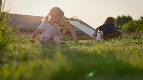 Duas Crianças Parque Infantil Menina Com Cabelo Loiro Sentado Grama — Vídeo de Stock