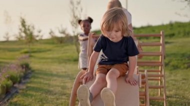 Çocuk parkındaki çocuklar. Üç şirin çocuk. Çocuklar eğleniyor. Çocuklar Aşağı Kayın.