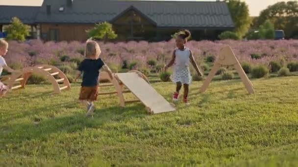 Children Play Wooden Slide Yard Two Girls White Black Boy — Stockvideo