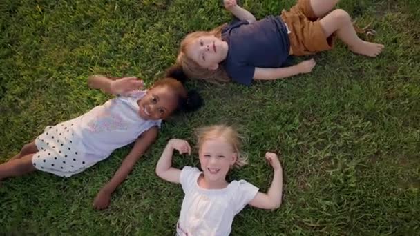 Трое Детей Лежащих Траве Похоже Прекрасный Летний Солнечный День Черно — стоковое видео