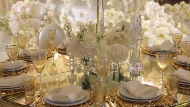 レストランで絶妙なお祭りテーブル テーブルは花で飾られ 提供されています 光の色で 特別なイベントのためのレストランで絶妙な料理 バラの多く — ストック動画
