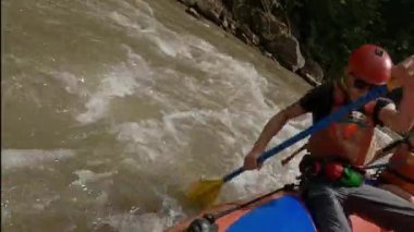 Teknedeki adam dağ nehrinde rafting yapıyor. Aktif olarak kürek çekiyor. Fast Mountain River Kasklı Adam ve Rafting Suit. Sıradışı Dinlenme .