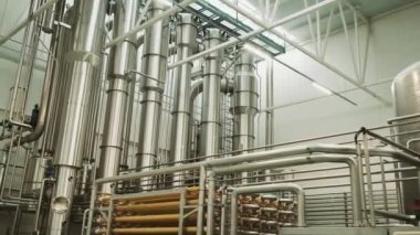 Juice Prodüksiyon Ekipmanı. Modern Fabrika. Otomatik Pompalama İstasyonu Suyu Borulardan Pompalıyor. Ekipman yüksek kaliteli paslanmaz çelikten yapılmıştır. Endüstriyel Lambalar Odayı aydınlatıyor