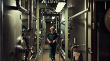 Juice Prodüksiyon Ekipmanı. İşçi Ekipmanları Ayarlar. Atölyede Bir Kadın Çalışıyor. Koruyucu önlemler: Kulaklıkları, bornozu, saçı ve koruyucu gözlükleri koruma kaptanı.