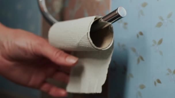 Man Unwinds Toilet Paper Paper Empty Sleeve Holder — Stockvideo