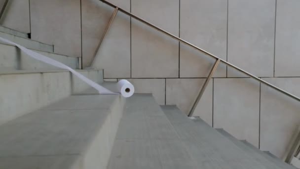 トイレペーパーは階段を転がっています 白い柔らかいトイレタリーペーパー — ストック動画