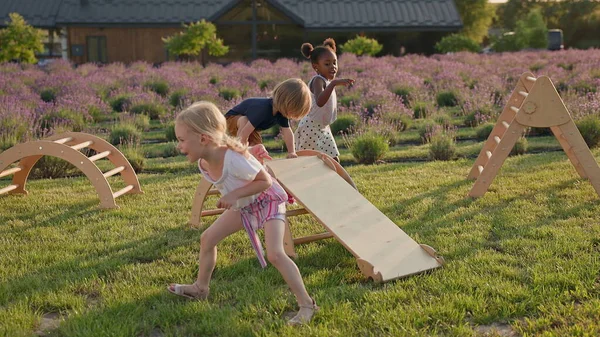 Lapset Leikkivät Puudialla Pihalla Kaksi Tyttöä Valkoinen Musta Poika Juoksentelee — kuvapankkivalokuva