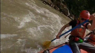 Teknedeki adam dağ nehrinde rafting yapıyor. Aktif olarak kürek çekiyor. Fast Mountain River Kasklı Adam ve Rafting Suit. Sıradışı Dinlenme .