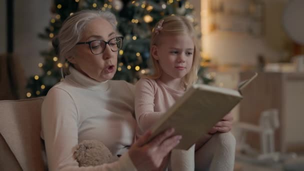 Yeni Yıl Tatilleri Büyükannem Torun Kitabı Okuyor Kanepede Birlikte Oturuyorlar — Stok video