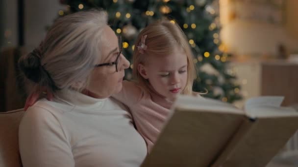 Yeni Yıl Tatilleri Büyükannem Torun Kitabı Okuyor Kanepede Birlikte Oturuyorlar — Stok video