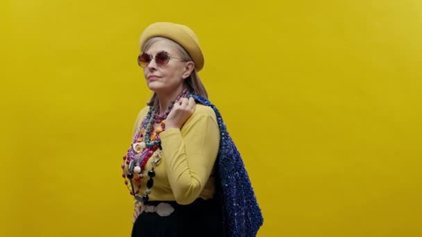 Стильная Пожилая Женщина Жёлтом Фоне Носит Шляпу Очки Женщина Пиджаком — стоковое видео