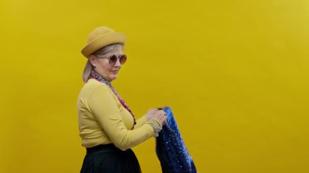 Стильная Пожилая Женщина Жёлтом Фоне Носит Шляпу Очки Женщина Пиджаком — стоковое видео