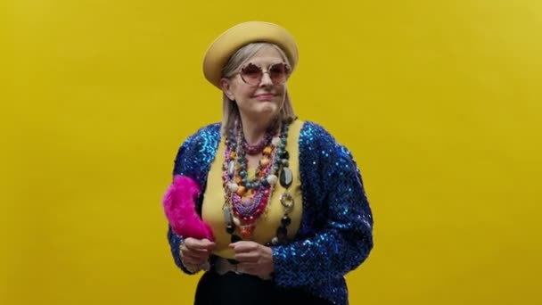 Sarı Arka Planda Şık Yaşlı Bir Kadın Şapka Gözlük Takıyor — Stok video