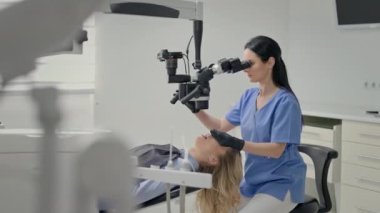 Ofiste çalışan dişçi. Ekipmanla koşan genç kadın. Sandalyedeki genç sarışın. Dişçide Resepsiyon.