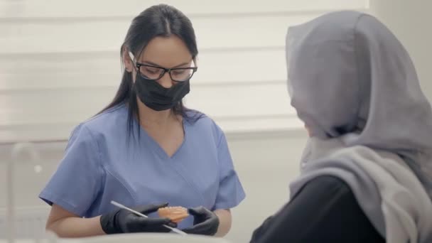 Dentysta Pracujący Biurze Twarz Młodego Pacjenta Blisko Młoda Dziewczyna Szaliku — Wideo stockowe