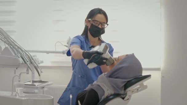 Dentysta Pracujący Biurze Twarz Młodego Pacjenta Blisko Młoda Dziewczyna Szaliku — Wideo stockowe