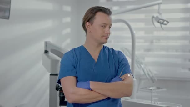 歯科室に立つ若い医師 白人の笑顔 胸に手を置いて — ストック動画