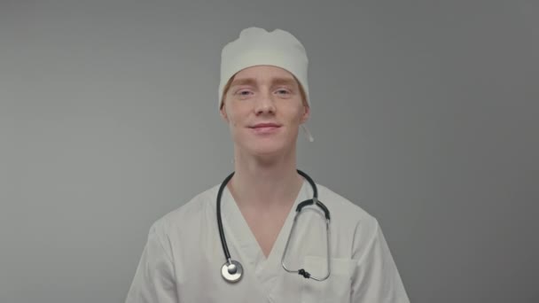 白い帽子の若い医師の顔 男とともにそばかすと赤い髪 — ストック動画