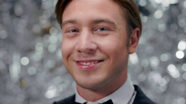 Boynunda kelebek ve takım elbiseli gülümseyen genç adamın portresi. Parti.