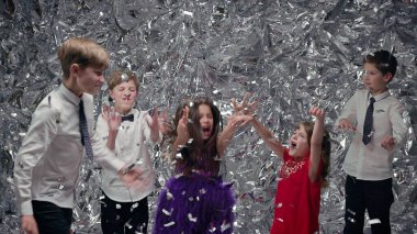 Gümüş Sahne Arkaplanındaki Beş Çocuk. Kutlama. Üç Oğlan ve İki Kız. Neşeli Çocuklar. Sırları kusar ve zıplarlar..