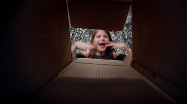 Küçük Kız Açık Kutusu. Seviniyor. Kutunun ortasından bak. Uzun Saçlı Şirin Bebek Tatil Elbisesi.