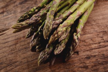 Tahta masada bir demet taze kuşkonmaz.