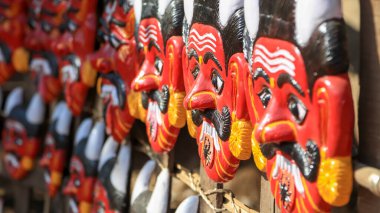 Colorful Hindu mythological demon handicraft masks up for sale , selective focus .